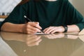 Close-up hands of unrecognizable young woman writing handwritten letter sitting at table at home, selective focus Royalty Free Stock Photo