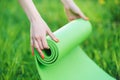 Close up hands unrolling bright green exercise mat
