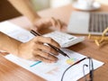 Close-up hands using calculator and holding pen, focusing on financial papers Royalty Free Stock Photo