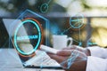Close up of hands using cellphone and laptop keyboard on desktop with coffee cup and creative polygonal blockchain hologram and