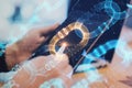 Close up of hands using digital pad with creative glowing blockchain hologram on blurry desktop background. Cryptocurrency and