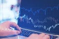 Close up of hands using laptop with forex chart on blurry desktop. Technology and trade concept. Royalty Free Stock Photo