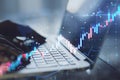 Close up of hands using laptop keyboard with glowing candlestick forex chart on blurry background. Trade, finance and growing Royalty Free Stock Photo