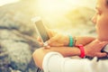 Close up of hands using modern smart phone, sunny day, sunlight, she chatting with friends at social network. Girl walking in Royalty Free Stock Photo