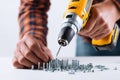 Close Up Of Hands Using A Power Drill With Screws And Nuts Royalty Free Stock Photo