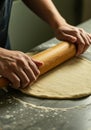 Hands gently use a rolling pin to flatten the dough for baking on the table Royalty Free Stock Photo