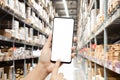 Close-up hands using smartphone in warehouse industry blur background for logistic wholesale storehouse, Online shopping concept. Royalty Free Stock Photo