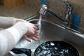 Close up of hands washing silverware