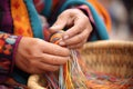 close-up of hands weaving a basket amid colorful yarns