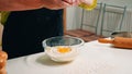 Close up of hands woman adding eggs in flour