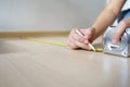 Close up hands woman engineer with yellow carpenters tape measuremeasure tape at construction site. background construction