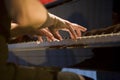 Close-up on the hands of a woman playing the piano with music keys