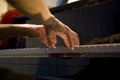 Close-up on the hands of a woman playing the piano with music keys