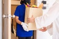 Close up hands woman receive paper bag food from delivery at home,Delivers takeaway meal Royalty Free Stock Photo