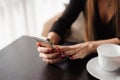 Close up of hands woman using her cell phone in restaurant, cafe Royalty Free Stock Photo