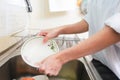 Close up hands of woman washing dishes in kitchen. Royalty Free Stock Photo