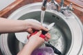 Close up hands of woman washing dishes in kitchen. Cleaning chores Royalty Free Stock Photo