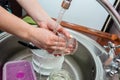 Close up hands of woman washing dishes in kitchen. Cleaning chores Royalty Free Stock Photo