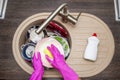 Close up hands of woman washing dishes in kitchen. Hands in red rubber gloves washing the dishes. Top view Royalty Free Stock Photo