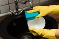 Close up hands of Woman Washing Dishes in the kitchen. Hands with sponge wash the plate under running water Royalty Free Stock Photo