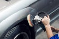 Close-up of hands worker using polisher to polish a gray car body in the workshop Royalty Free Stock Photo