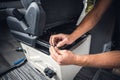 Close up of hands working on a seat inside a van