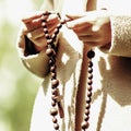 Close up hands of young girl holding rosary. Pray, God concept Royalty Free Stock Photo