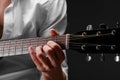 Close-up of hands of a young man playing guitar on a black background. Musical instrument, art concept. Royalty Free Stock Photo