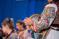 Close up of hands of young Romanian girl in traditional folkloric costume. Folklore of Romania