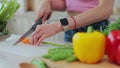Close up of hands of young woman cutting vegetables in the kitchen. Preparing fresh vegetable salad. Dieting concept. Royalty Free Stock Photo