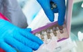 Close-up hands of young woman doctor anesthesiologist dressed in pink gown, blue gloves prepares solution for anesthesia Royalty Free Stock Photo