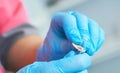 Close-up hands of young woman doctor anesthesiologist dressed in pink gown, blue gloves prepares solution for anesthesia Royalty Free Stock Photo