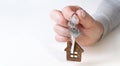 Close up of hands of young woman holding house keys of her new house. Woman hand holding housekey shaped keychain. Girl Royalty Free Stock Photo