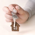 Close up of hands of young woman holding house keys of her new house. Woman hand holding housekey shaped keychain. Girl Royalty Free Stock Photo