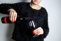 Close up of the hands of a young woman pouring red wine into a glass from a bottle Royalty Free Stock Photo