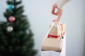 close-up of the hands of a young women carrying a paper bag full of gift boxes decorated with a red ribbon on a blue background Royalty Free Stock Photo