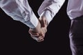 Concept of a reliable partnership: a close-up of handshake of business partners on a black background. Royalty Free Stock Photo
