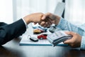 Close up of a handshake at the table with toy car and keys. Car buying concept. successful car loan contract buying or selling new Royalty Free Stock Photo