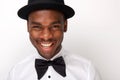Close up handsome african american man smiling with bowtie and hat against white background Royalty Free Stock Photo