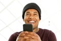 Close up handsome african american man smiling and holding cellphone Royalty Free Stock Photo