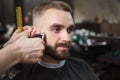 Bearded man getting new haircut at barbershop