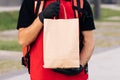 Close up handsome courier man holding paper bag with food at street outdoors worker grocery to house door to door Royalty Free Stock Photo