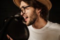 Close up handsome male musician emotionally singing in microphone recording song in professional sound studio