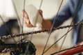 Close up of handsome man in casual clothing lubricate the bike chain with oil at home Royalty Free Stock Photo