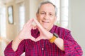 Close up of handsome senior man at home smiling in love showing heart symbol and shape with hands Royalty Free Stock Photo