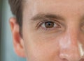 Close-up of handsome western man face skin. Male eye. Texture of the dark brown eye is visible. Macro detail. Caucasian