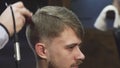 Close up of a handsome yougn man getting a haircut at the barbershop