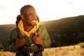 Close up handsome young african american man with backpack smiling with sunset in background Royalty Free Stock Photo