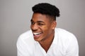 Close up handsome young african american man laughing and looking away against gray background Royalty Free Stock Photo