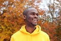 Close up handsome young african american man smiling against autumn leaves in background Royalty Free Stock Photo